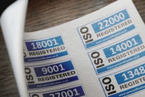 Services ISO certification stickers with registration numbers on paper.